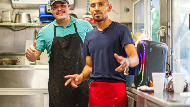 Deux cuisiniers d'un atelier agroalimentaire en pleine discussion devant leur poste.